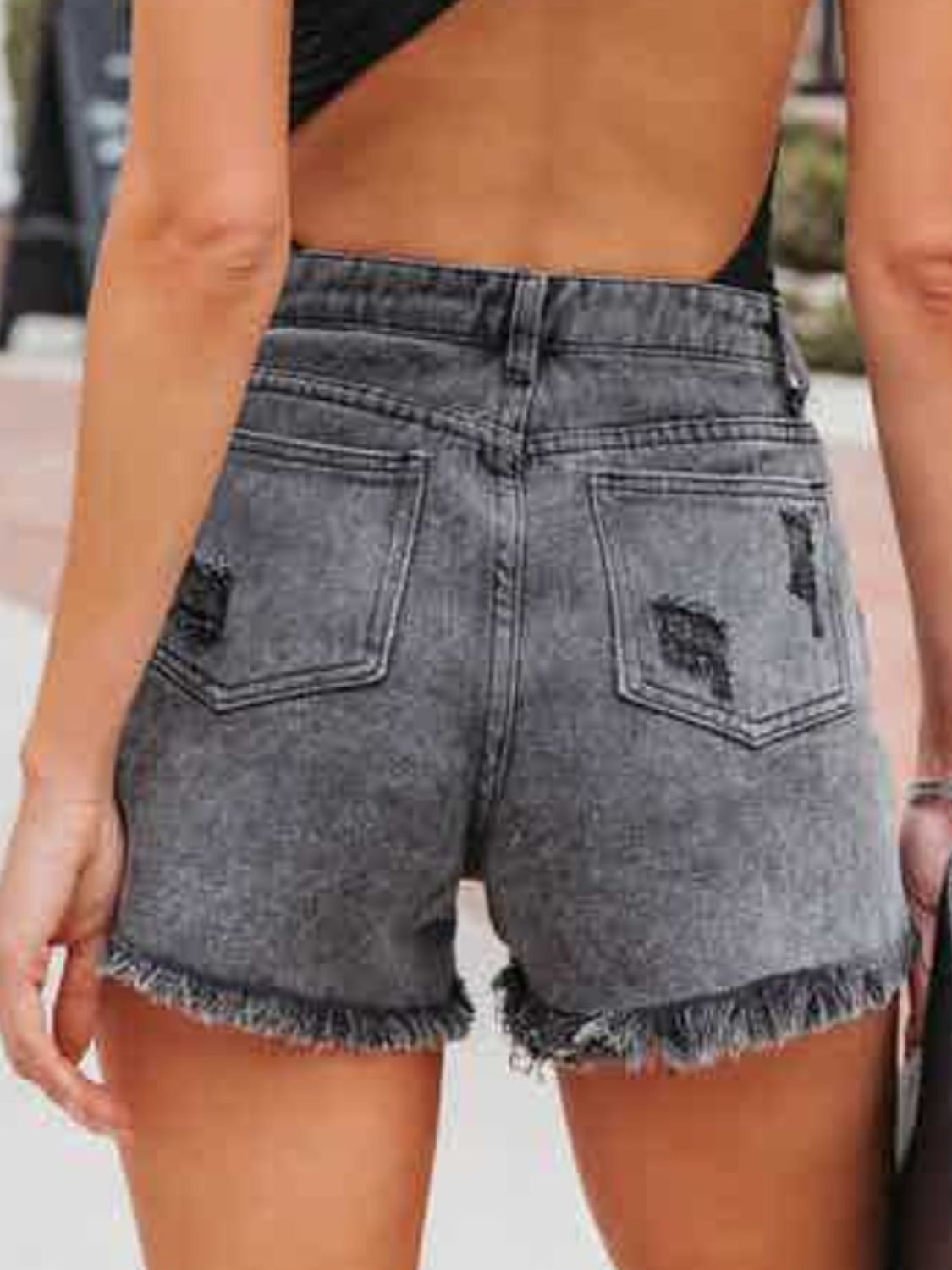 Pantalones cortos de mezclilla desgastados con flecos y bolsillos